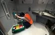 Un empleado del ferrocarril Deutsche Bahn (DB) en Alemania limpia un inodoro de un tren.
