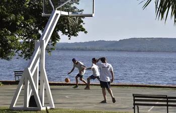 Con el lago de fondo, estos amigos disfrutan de un partido de basquet.