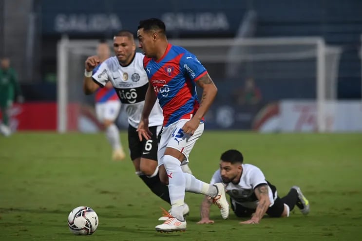 Ángel Lucena de Cerro Porteño traslada el balón ante la marca de Richard Ortiz y Víctor Salazar de Olimpia, en La Nueva Olla.