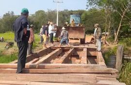 Un grupo de pobladores trabaja en la reparación de la pasarela de madera ubicada sobre el arroyo Tapiracuai del municipio de Santaní.