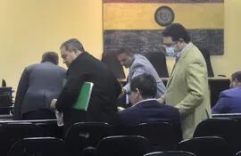 El diputado Rubén Roussillón (con carpeta en verde) y José Ortiz, expresidente de Conajzar, se presentaron esta mañana en la audiencia preliminar ante el juez Humberto Otazú.