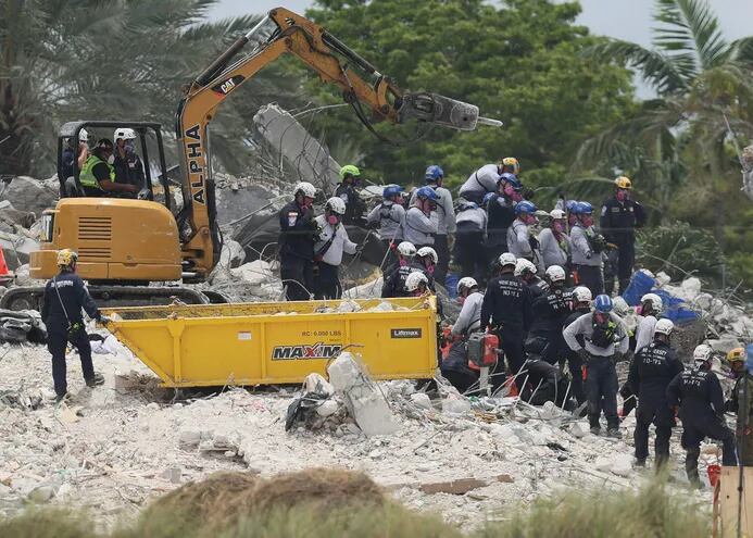 Rescatistas trabajan en busca de los desaparecidos, tras el colapso del condominio Champlain Towers South, en Miami-Dade. (AFP)
