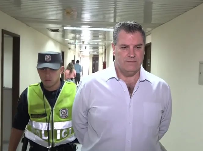 Esposado, el exbanquero uruguayo José Peirano Basso es conducido al juzgado penal de garantías N° 1, a cargo de Clara Ruiz Díaz. Fue el jueves pasado.