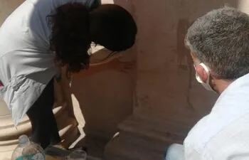 Alicia Vega y Carlo Spatuzza trabajan en la eliminación de las pintatas en la fachada del Panteón Nacional de los Héroes.