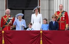 La reina Isabel II apareció en el balcón del Palacio de Buckingham vestida con abrigo y sombrero azul. Sonriente y de pie junto a sus hijos y nietos, herederos de la corona. (AFP)