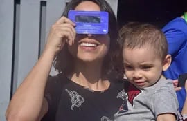 Una madre observa un eclipse solar con su hijo en brazos.