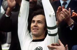Una imagen de archivo fechada el 7 de julio de 1974 muestra al capitán de la selección alemana, Franz Beckenbauer, levantando el trofeo de la Copa del Mundo en el Estadio Olímpico de Múnich después de la final de la Copa del Mundo de 1974 entre Alemania y los Países Bajos, que Alemania ganó 2-1, reeditada el 8 de enero de 2024.