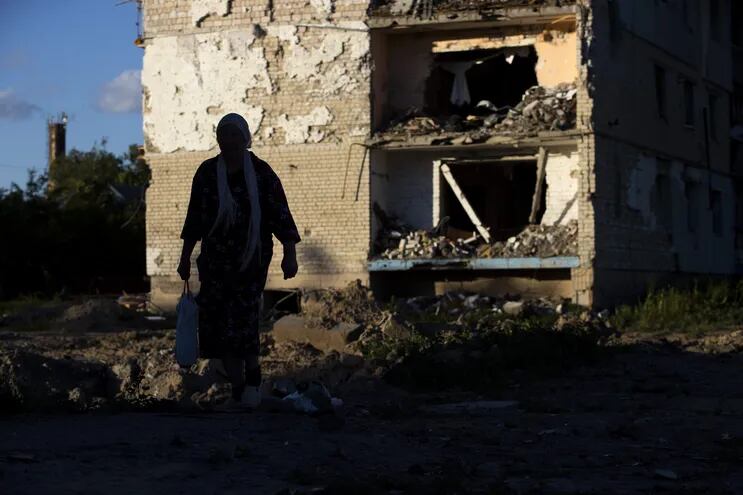 Una mujer camina hoy cerca a un edificio destruido, en Borodyanka (Ucrania).