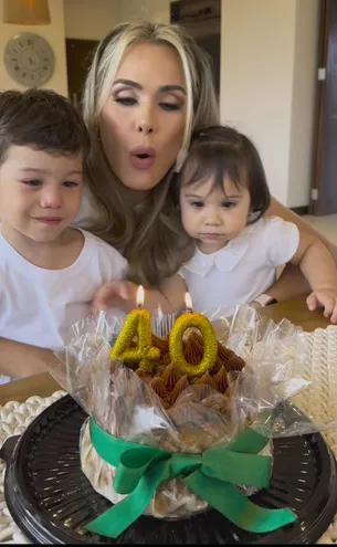 Tania Domaniczky a punto de apagar las velitas de la torta de cumpleaños junto a sus hijos Maxi y Mía.