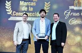 Lic. Julio Mendoza (i), presidente de la Cámara Paraguaya de Consultores, entrega el premio a los ingenieros Juan Villasanti (centro) y José Luis Vinader Ashwell de BH Concretos.