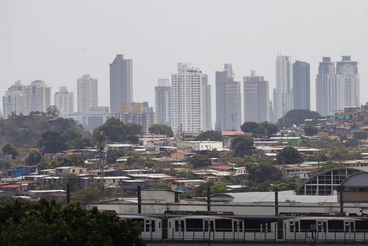 Fotografía que muestra casas en el distrito de San Miguelito y atrás los edificios de Costa del Este de la Ciudad de Panamá (Panamá).