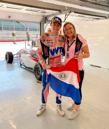Junto a su madre Rommy Dick, Joshua posa con sus trofeos y la infaltable bandera paraguaya.