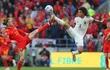 El galés Gareth Bale (i) y el belga Axel Witsel estiran las piernas en procura del balón, durante el partido que jugaron y empataron ayer en Cardiff.