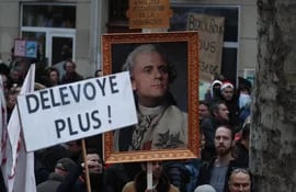 Manifestantes sostienen un retrato del presidente francés Emmanuel Macron representado como Luis XVI, en una manifestación contra la reforma de las pensiones cerca de la plaza de la Bastilla, en París.