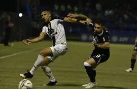 Marcelo Paredes de Tacuary disputa el balón con Víctor Salazar de Olimpia, en el Luis Alfonso Giagni.