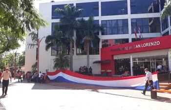 Los funcionarios que no perciben sus salarios extendieron la bandera paraguaya frente al edificio comunal.