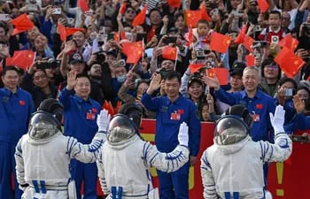 Los astronautas de la misión espacial Shenzhou-18 de China (de izquierda a derecha) Li Guangsu, Li Cong y Ye Guangfu saludan durante una ceremonia de salida antes de abordar un autobús que los llevará a la nave espacial Shenzhou-18 en el Centro de Lanzamiento de Satélites de Jiuquan en el desierto de Gobi en noroeste de China.