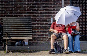 Una pareja se resguarda de los rayos de sol bajo un paraguas, este jueves en Ámsterdam (Holanda).