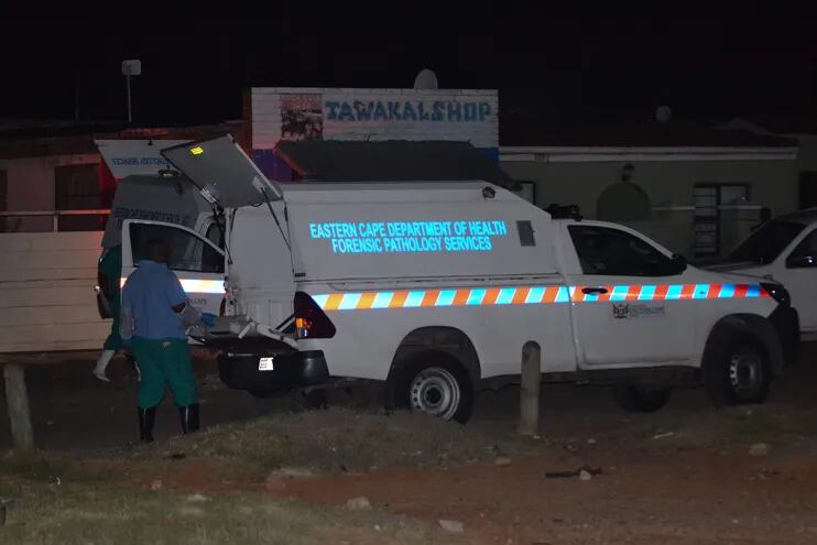 Los miembros de los Servicios de Patología Forense se paran cerca de sus vehículos en la escena de un tiroteo masivo en Gqeberha, Sudáfrica, este 29 de enero de 2023.