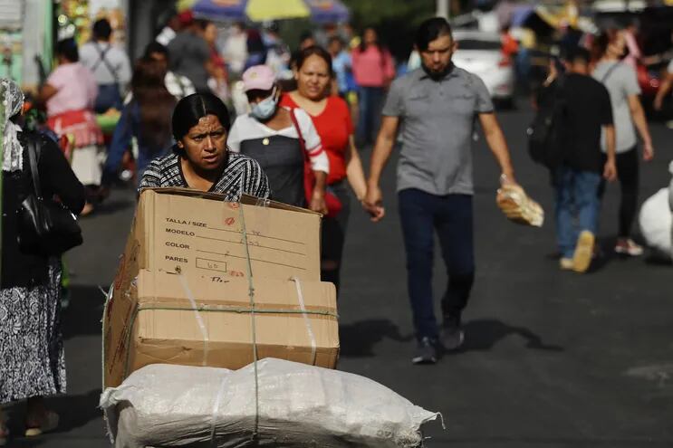 Una vendedora traslada su mercadería a un puesto de ventas, el 2 de marzo de 2023 en San Salvador (El Salvador). Una diferencia salarial que oscila entre el 15 % y el 30 % y una carga del cuidado históricamente puesta en manos de esposas, hijas y madres son algunas de las grandes barreras económicas a las que se enfrentan las mujeres en Latinoamérica. La brecha salarial en El Salvador es del 15 %, equivalente a unos 54 dólares más para los hombres "realizando el mismo trabajo", apunta por su parte Carmen Urquilla, coordinadora del programa de Justicia Laboral y Económica, de la Organización de Mujeres Salvadoreñas por la Paz (Ormusa).