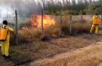 Bomberos tratan de sofocar las llamas que emergen desde el terreno de Manufactura de Pilar y amenazan el aeródromo de la capital del Ñeembucú.