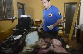 un-personal-policial-de-criminalistica-observa-los-restos-de-documentos-quemados-en-una-oficina-de-la-comuna-de-nueva-colombia--223815000000-1410628.jpg