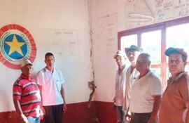 Padres de familia en una de las salas de clase con paredes agrietadas en la Colonia Mandu'arã