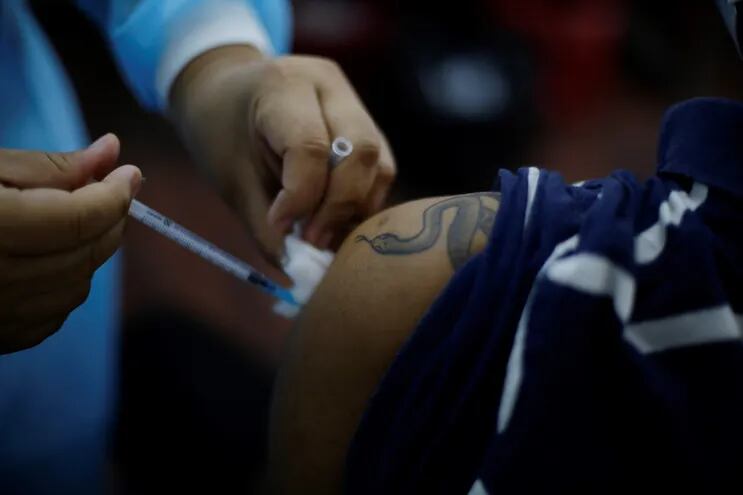 Un joven recibe su primera dosis de vacuna contra el covid-19 en San Salvador.