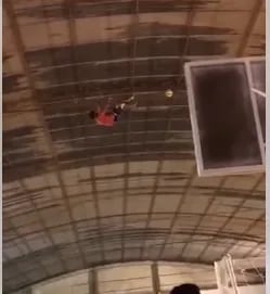Un "hombre araña" paraguayo baja pelotas del techo de un tinglado en Yby Yaú.