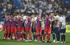 Los jugadores de Alianza Lima (d) y de Cerro Porteño en el saludo previo al partido por la fase de grupos de la Copa Libertadores 2024 en el estadio Alejandro Villanueva, en Lima, Perú.
