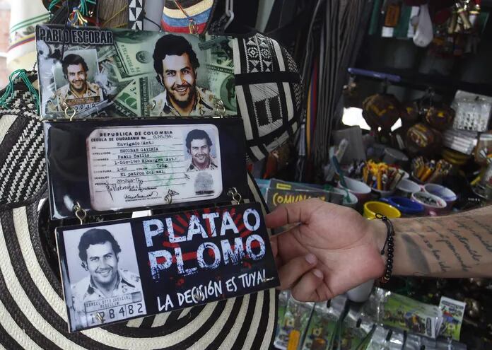 Un hombre ofrece productos con imágenes alusivas al narcotraficante colombiano Pablo Escobar, el 28 de noviembre de 2023, en Medellín, Colombia. Su figura ha sido parte de varias series de televisión, libros y canciones.