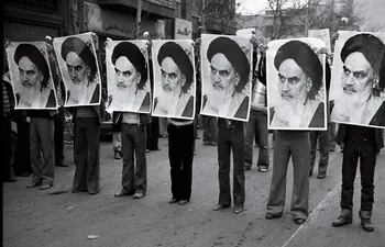 Irán, 1978: fila de hombres con fotos de Jomeini.