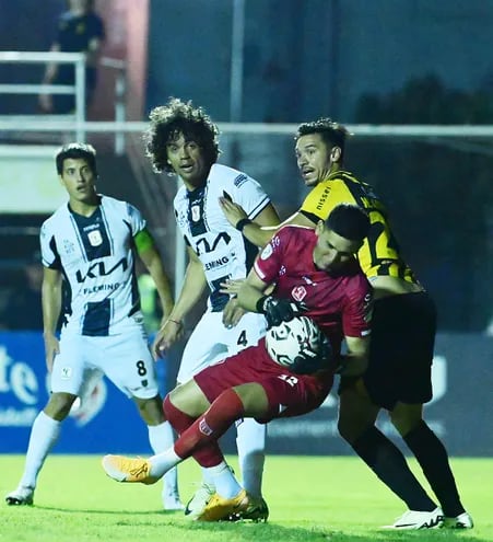 El arquero de Tacuary, Aldo Bareiro atrapa el balón ante las  miradas de Walter González y Édgar Benítez (4) y Ronal Domínguez (8).