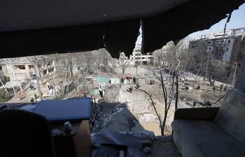 Ucranianos inspeccionan un edificio parcialmente dañado por misiles rusos en Kiev (Kyiv), Ucrania.
