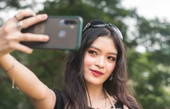 Una joven se toma una selfi con su teléfono celular.