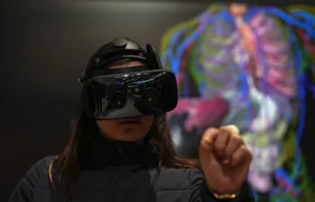 Una visitante estudia la anatomía humana a través de realidad virtual en el expositor de Analog Devices en el Mobile World Congress (MWC), el mayor congreso de tecnologías móviles del mundo, que arrancó en Barcelona. (EFE)