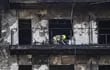 Bomberos y Policía Científica inspeccionan un cuerpo en un balcón del edificio incendiado en el barrio de Campanar de València. La cifra de víctimas mortales en el incendio se eleva a 10 tras la primera inspección ocular que han hecho en el interior de las instalaciones los bomberos y la Policía Científica.
