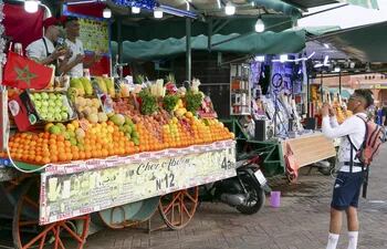 Dos vendedores de fruta posan para una foto en un mercado de Marrakech (Marruecos). Tras dos años de restricciones sanitarias, Marrakech, el pulmón turístico de Marruecos, está volviendo a la vida con plazas llenas de turistas y todos los comercios abiertos, aunque todavía no ha llegado a los niveles de visitantes prepandemia.