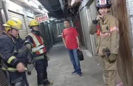 Juan Villalba, director del Mercado 4 y bomberos tras el principio de incendio que se registró este lunes de noche.