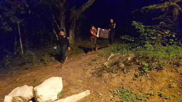 Policías bajan restos óseos del cerro Cristo Rey de Caacupé, que serían de María Ramona Cardozo.