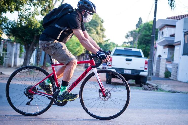 Un ciclista con barbijo circula por las calles de Asunción. La pandemia generó un auge del uso de bicis como medio de transporte, ya que la gente buscar evitar los colectivos.