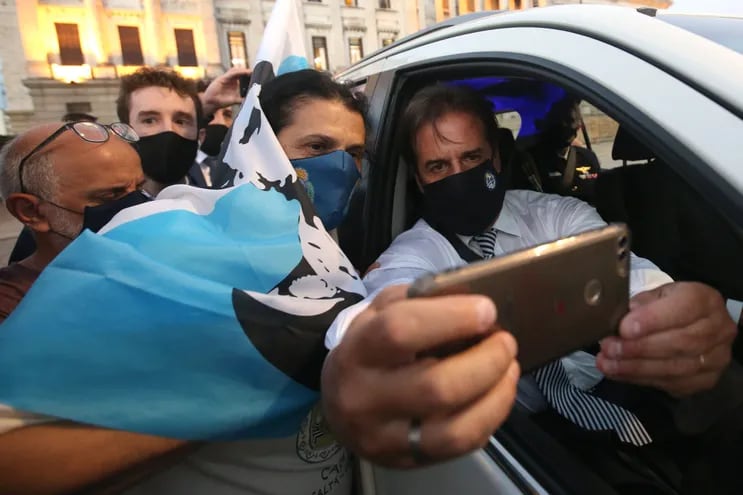 El presidente de Uruguay Luis Lacalle Pou (d) se toma una foto con una seguidora después de ofrecer un discurso hoy, en el Parlamento en Montevideo.