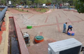 Trabajadores de la Municipalidad de Asunción, trabajando por los cables sueltos que quedaron por las bases de cemento.