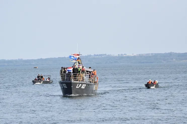 La procesión náutica a través del río Paraná a bordo de una patrullera de la Prefectura Naval de Itapúa, escoltada por embarcaciones menores, en el marco de un atractivo paisaje.