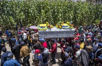 Vecinos y familiares asisten al entierro de los restos del menor Pascual Melvin Guachiac Sipac de 13 años, en el cementerio de la aldea Tzucubal, Nahualá (Guatemala). El menor murió asfixiado en un camión el pasado 27 de junio en San Antonio, Texas cuando con un grupo de migrantes intentaba llegar a los Estados Unidos.