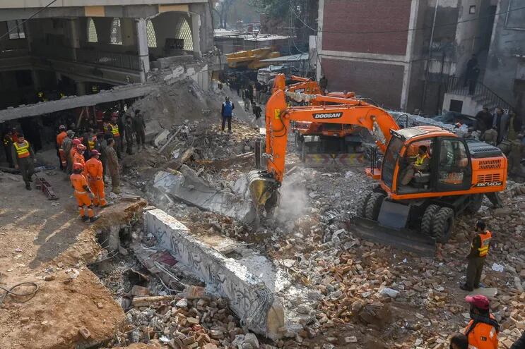El personal de seguridad y los rescatistas buscan víctimas entre los escombros de una mezquita dañada un día después de una explosión dentro de la sede de la policía en Peshawar el 31 de enero de 2023.