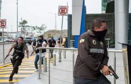 Policías ecuatorianos se movilizan en las inmediaciones del canal televisivo TC, tomado por atacantes armados, el martes en Guayaquil.