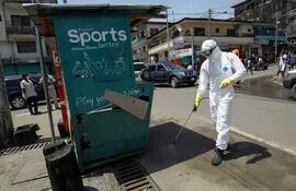 Un hombre desinfecta un puesto público en Libera, África occidental.