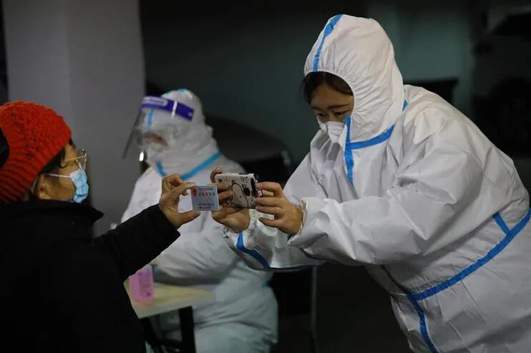 Un trabajador médico toma fotos de la información de identidad de los residentes durante las pruebas masivas de COVID-19 en Shijiazhuang, Hebei.