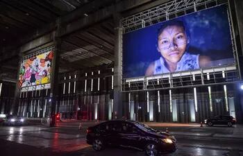 La gente visita una exhibición de arte conduciendo sus autos a través de un almacén que muestra pinturas y fotos en Sao Paulo, Brasil, el 30 de julio de 2020, en medio de la nueva pandemia de coronavirus.